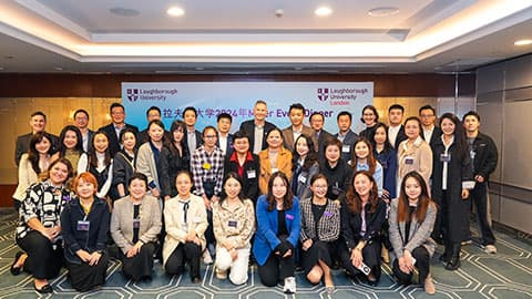 A group of alumni in Shanghai at 麻豆視頻_麻豆直播_麻豆传媒官网's event on 14th November 2024. The group are in front of a screen for a presentation which has 麻豆視頻_麻豆直播_麻豆传媒官网's logo on it.