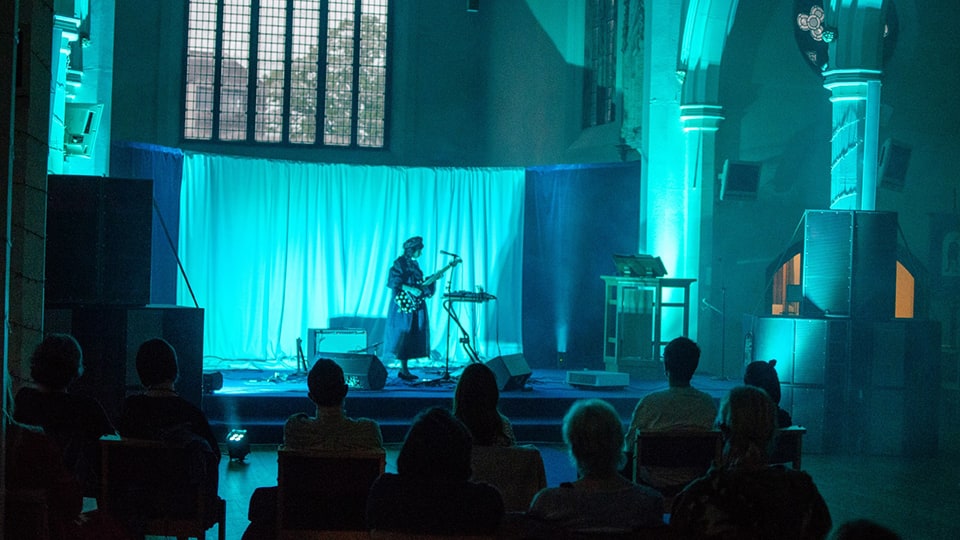 Musical performance against a blue lit background