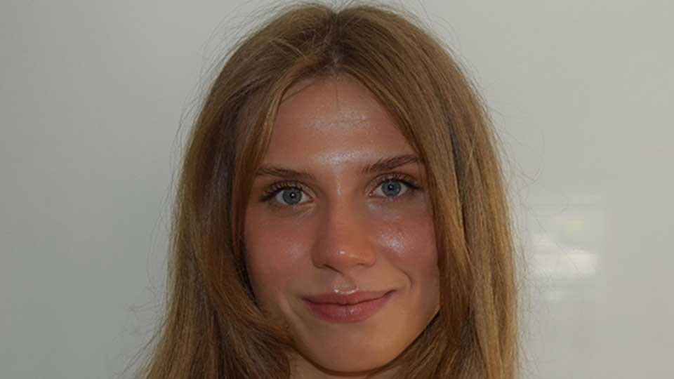 Headshot of a female student in early twenties with long dark blonde hair