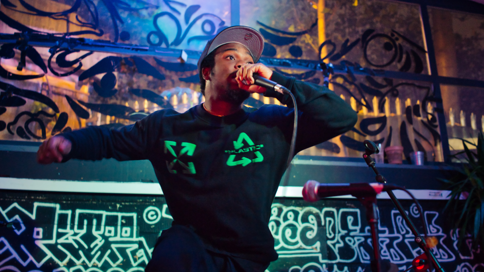 A person on stage rapping into a microphones