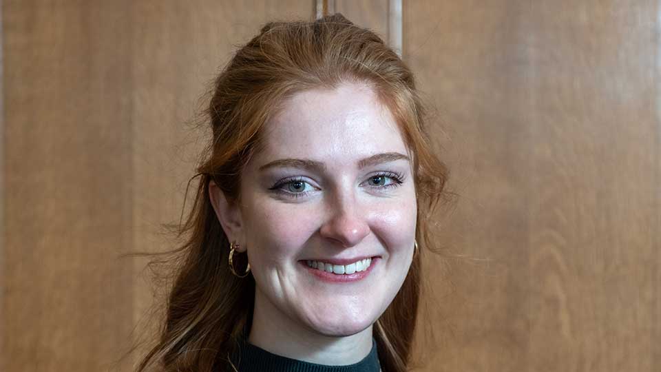 Young white female in her early twenties, smiling, with long red hair tied back