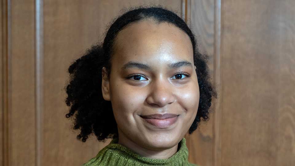 Young female of white and black African heritage with black hair tied back