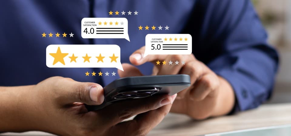 A person using a smartphones with star graphics representing online reviews popping out of the screen.