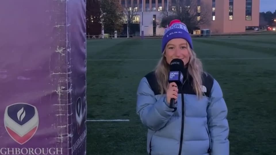 Bella Harris-Johnstone standing outside on a sports pitch with a microphones.