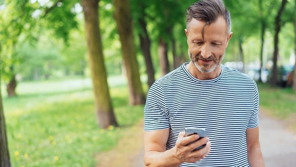 Man looking at phones near trees