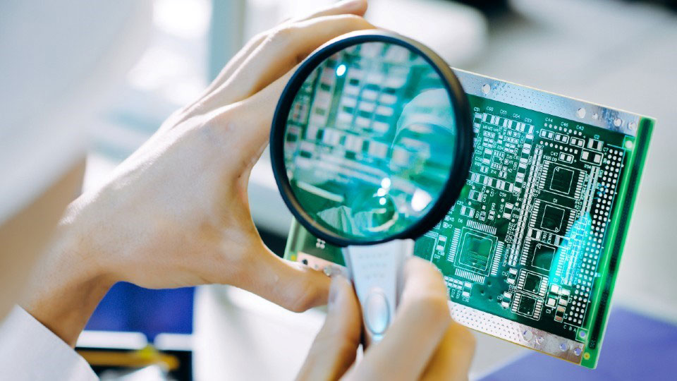 Someone holding a magnifying glass on a computer chip