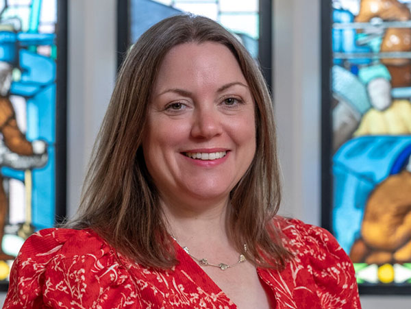 Portrait of Kathryn North against a stained glass window