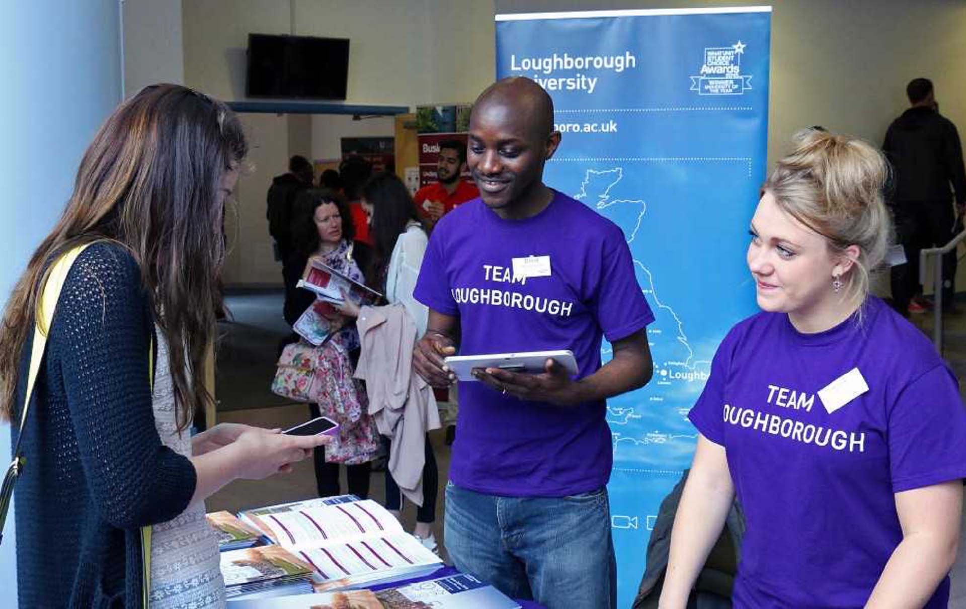Two Loughborough Student Ambassadors helping a visitor at a 麻豆視頻_麻豆直播_麻豆传媒官网 open day.  