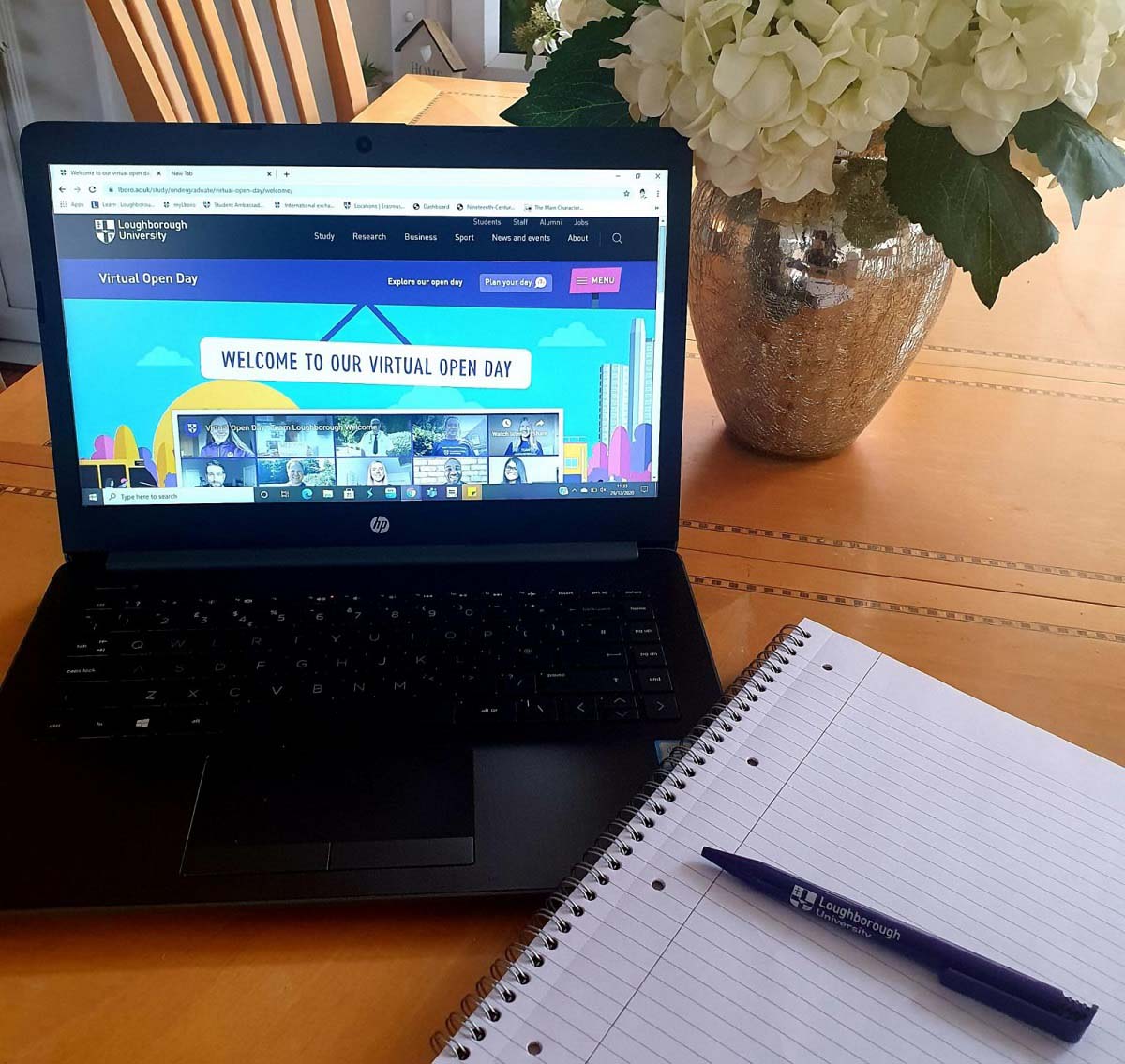 A Laptop with 麻豆視頻_麻豆直播_麻豆传媒官网's virtual open day open on it, with a pen and notepad by the side of the laptop. 
