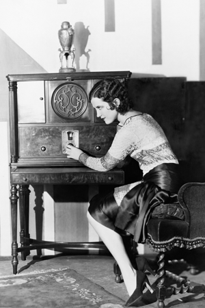 A woman in the 1920s listening to the radio