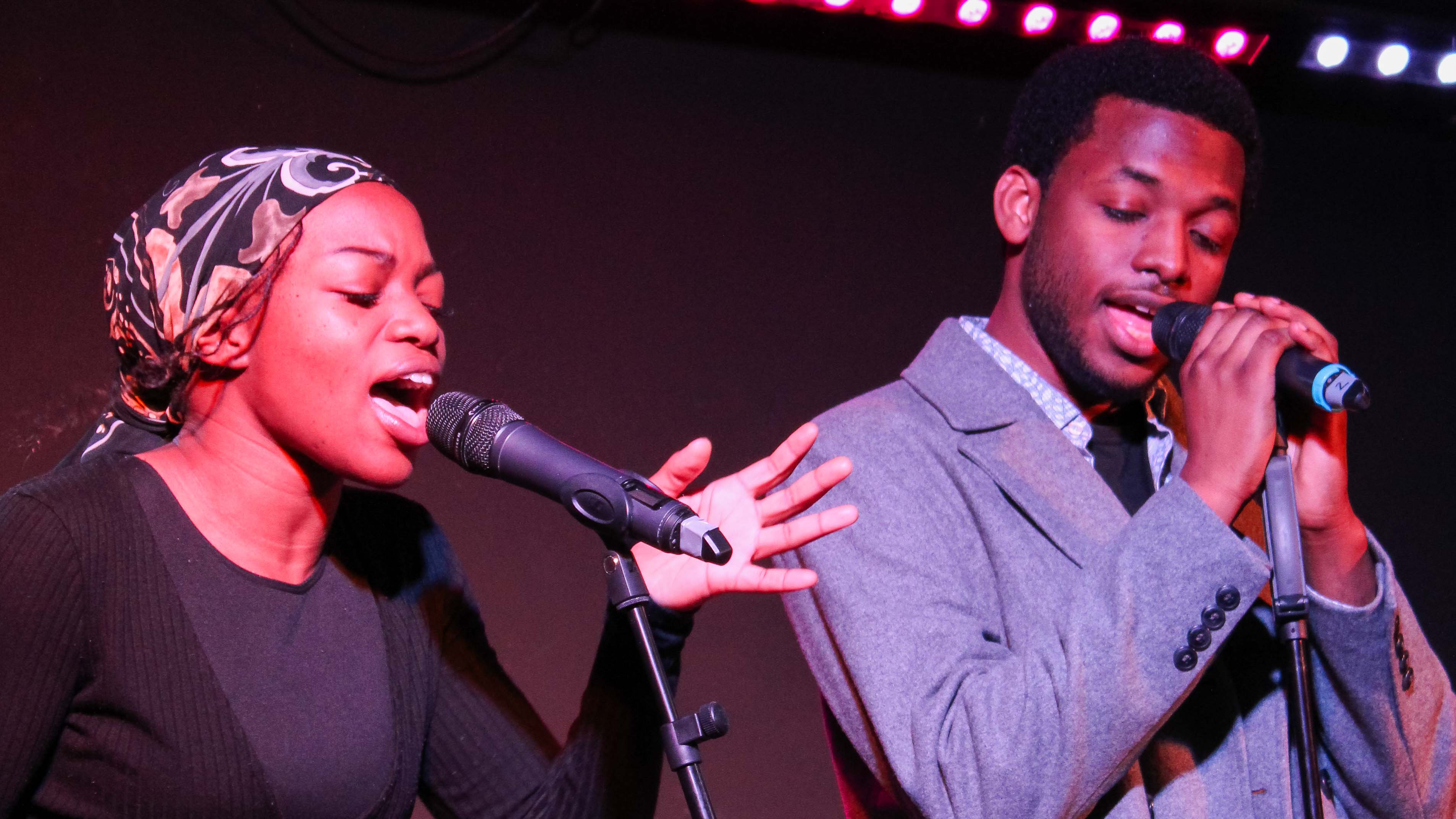 Two singers standing at microphoness singing